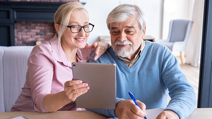 Älteres Paar sieht sich auf dem Tablet Jobs für Rentner an