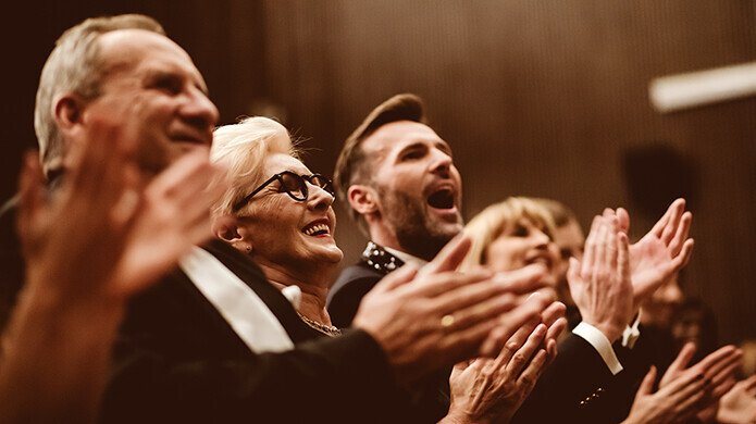 Menschen applaudieren auf einem Konzert
