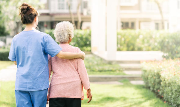 nurse-caregiver-support-walking-with-elderly-woman-outdoor.jpeg